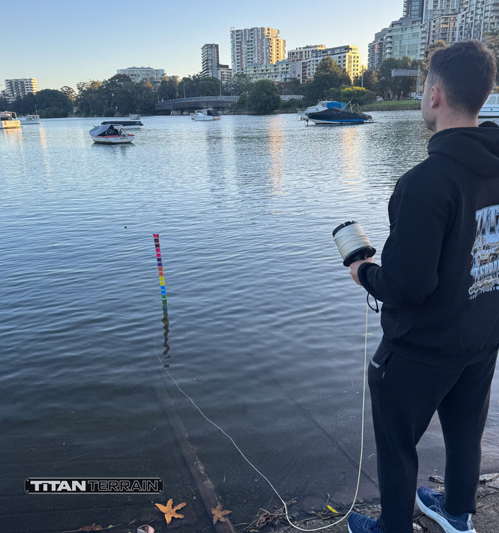 Person demonstrating titan terrain depth gauge on lake with boats